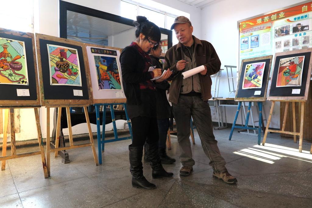 高国华与王璐阳老师在指导学生评画